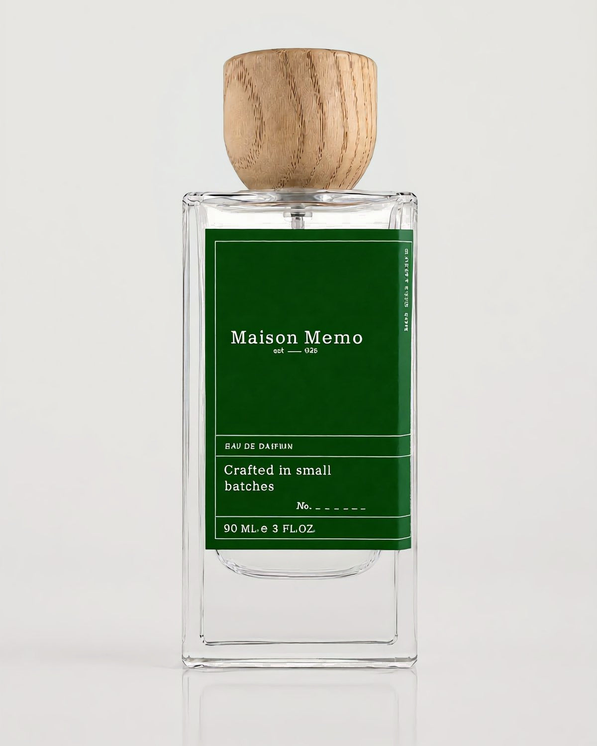 The 90 ml flacon square-on against white seamless, forest green letterpress label under a turned oak cap.