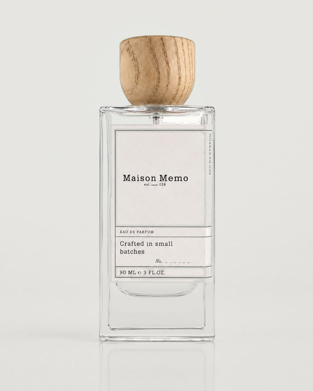 The 90 ml flacon square-on against white seamless, cream ivory letterpress label under a turned oak cap.