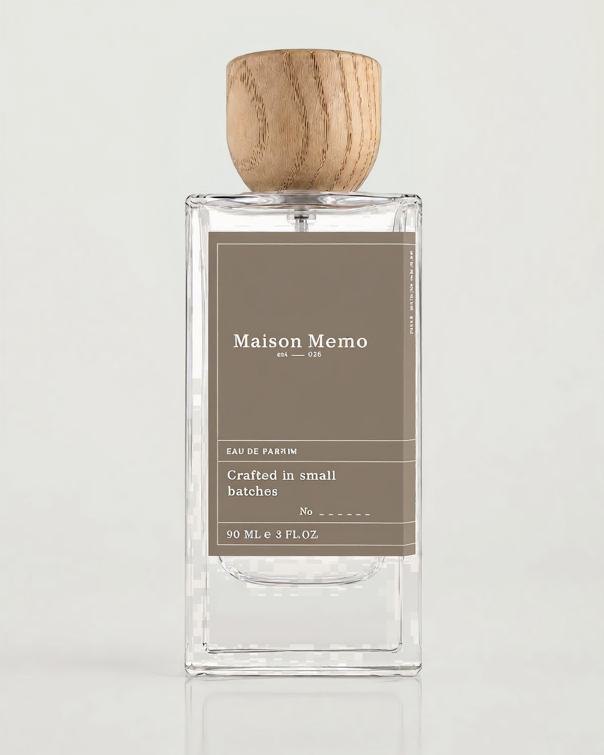 The 90 ml flacon square-on against white seamless, taupe letterpress label under a turned oak cap.